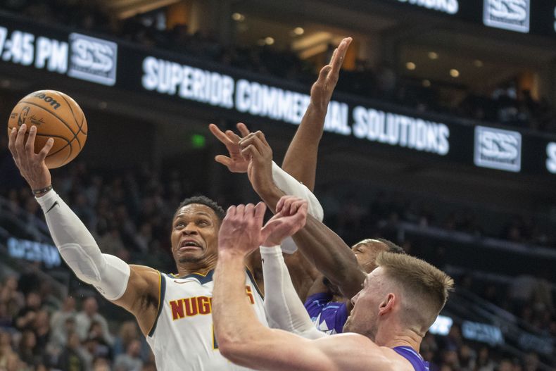 Russell Westbrook, de los Nuggets de Denver, encesta frente a Keyonte George y Drew Eubanks, del Jazz de Utah, el miércoles 27 de noviembre de 2024 (AP foto/Rick Egan)