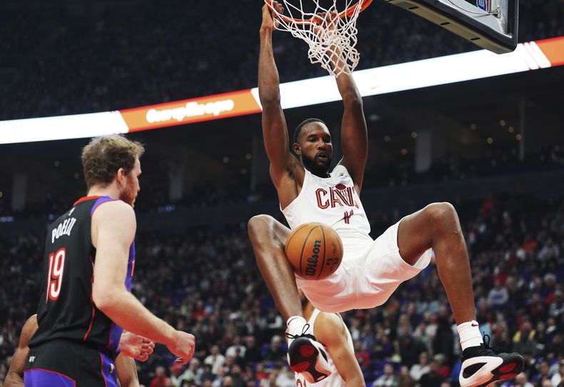 Evan Mobley, de los Cavaliers de Cleveland, realiza una clavada frente a Jakob Poeltl, de los Raptors de Toronto, el miércoles 23 de octubre de 2024 (Frank Gunn/The Canadian Press via AP)