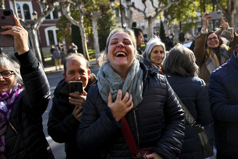 Unas personas festejan al conocer los números ganadores del premio mayor la lotería española, en Logroño, España. (AP Foto/Miguel Oses)