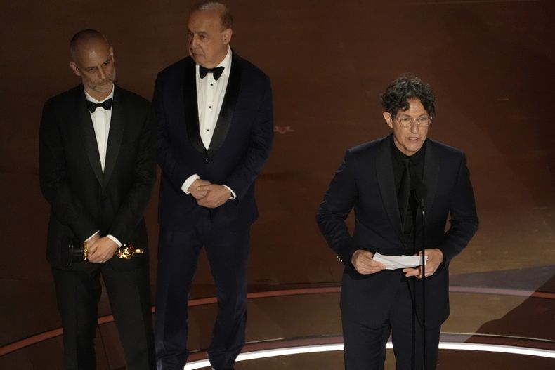 James Wilson (izquierda), Leonard Blavatnik (centro) y Jonathan Glazer aceptan el Oscar a mejor largometraje internacional por The Zone of Interest (Zona de interés) durante la entrega de los premios el domingo 10 de marzo de 2024, en el Teatro Dolby de Los Ángeles. (AP Foto/Chris Pizzello)