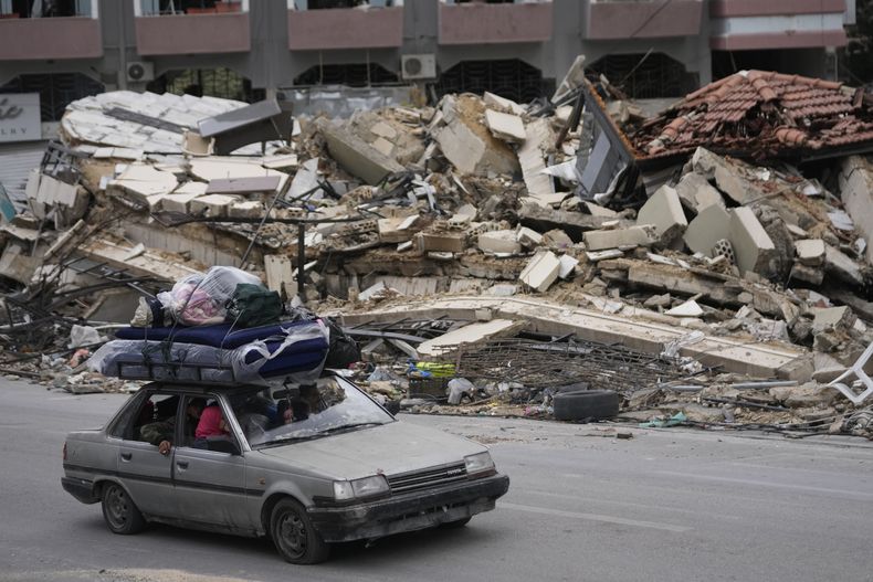 Residentes desplazados conducen entre escombros de edificios destruidos mientras regresan a sus aldeas, tras un alto el fuego entre Israel y Hezbollah que entró en vigor el miércoles 27 de noviembre de 2024 en Tiro, en el sur del Líbano. (AP Foto/Hussein Malla)