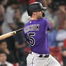 Randal Grichuk, de los Rockies de Colorado, conecta un doble de dos carreras en la décima entrada del juego ante los Medias Rojas de Boston, el martes 13 de junio de 2023 (AP Foto/Charles Krupa)