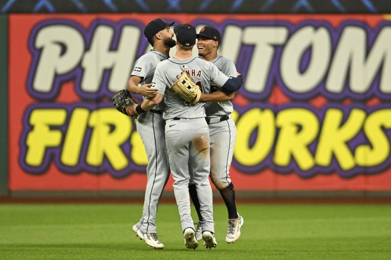 Riley Greene, a la izquierda, Wenceel Pérez, a la derecha, y Mark Canha, al centro, de los Tigres de Detroit, celebran después de su victoria sobre los Guardianes de Cleveland el lunes 22 de julio de 2024, en Cleveland. (AP Foto/Nick Cammett)