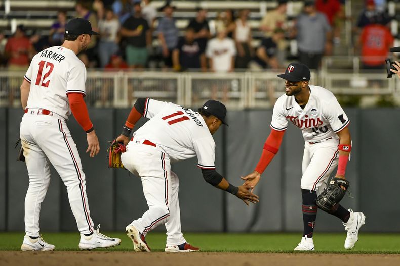 El puertorriqueño Willi Castro (derecha) festeja con el dominicano Jorge Polanco (11) y el campocorto Kyle Farmer tras el triunfo ante los Guardianes de Cleveland, el viernes 2 de junio de 2023 (AP Foto/Craig Lassig)