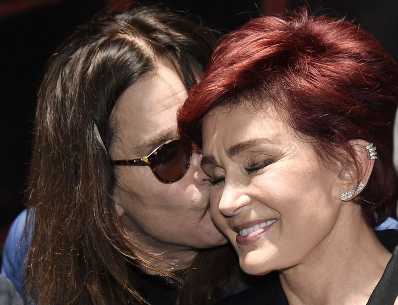 ARCHIVO - Ozzy Osbourne besa a su esposa Sharon durante la conferencia de prensa Ozzfest Meets Knotfest en el Hollywood Palladium, el 12 de mayo de 2016, en Los Ángeles. (Foto Chris Pizzello/Invision/AP, archivo)