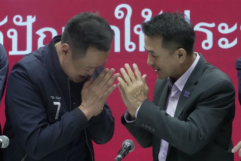 El líder del partido Bhumjaithai, Anutin Charnvirakul, izquierda, y el líder del partido Pheu Thai, Chonlanan Srikaew, se saludan al final de una conferencia de prensa en que anunciaron una coalición, en la sede del partido Pheu Thai en Bangkok, Tailandia, el lunes 7 de agosto de 2023. (AP Foto/Sakchai Lalit)