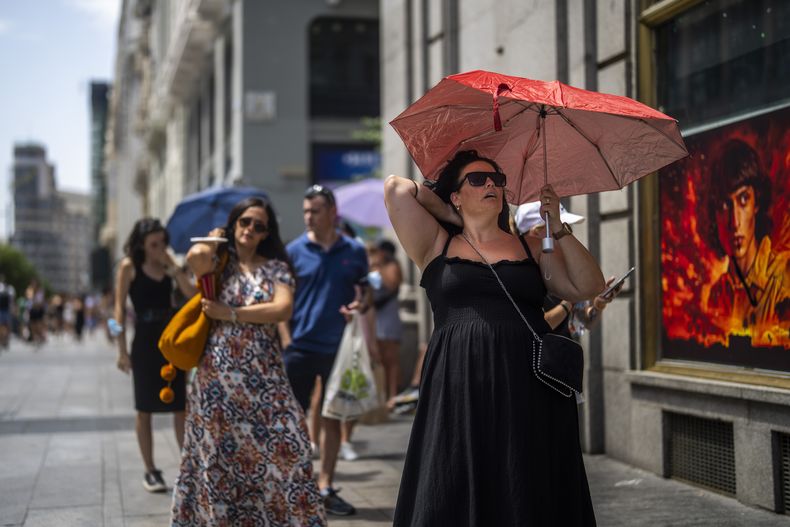 En esta imagen de archivo, una mujer se protege del sol con un paraguas durante un día caluroso en Madrid, el 18 de julio de 2022. (AP Foto/Manu Fernández, archivo)
