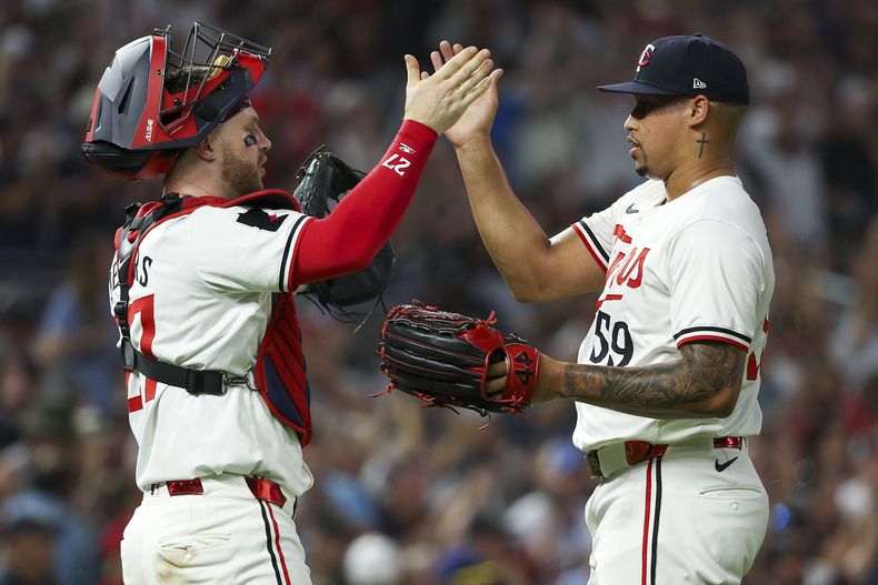El receptor de los Mellizos de Minnesota, Ryan Jeffers, a la izquierda, y el lanzador relevista Jhoan Duran, a la derecha, celebran después de su victoria sobre los Medias Blancas de Chicago el sábado 3 de agosto de 2024, en Minneapolis. (AP Foto/Matt Krohn)