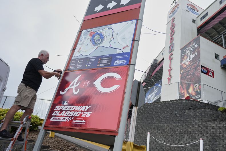 Rod Bruchell instala carteles en el exterior del Bristol Motor Speedway, el viernes 1 de agosto de 2025, en Bristol, Tennessee, el día antes del partido de béisbol del Clásico de Béisbol en el Speedway de la MLB entre los Rojos de Cincinnati y los Bravos de Atlanta. (AP Photo/George Walker IV)