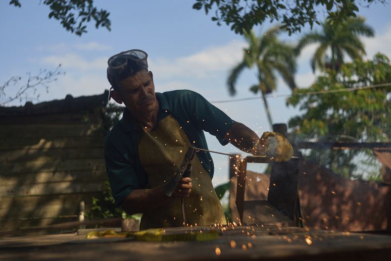 El herrero Edinector Vázquez construye una hornilla de carbón para vender a los ciudadanos para que puedan cocinar durante los apagones en Minas, La Habana, Cuba, el viernes 23 de mayo de 2025. (AP Foto/Ramón Espinosa)