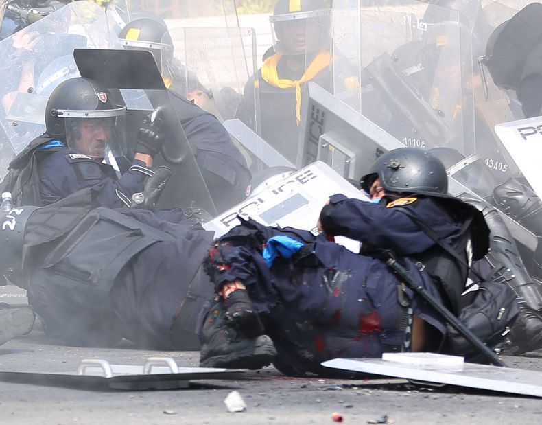 Un polic&iacute;a antimotines tailand&eacute;s cae herido tras el estallido de un explosivo durante los enfrentamientos entre fuerzas de seguridad y manifestantes que piden la dimisi&oacute;n de la primera ministra Yingluck Shinawatra el martes 18 de febr