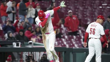 Elly De La Cruz, izquierda, de los Rojos de Cincinnati, celebra con el coach de tercera base J.R. House (56) después de batear un jonrón de dos carreras en la séptima entrada frente a los Rangers de Texas, el lunes 31 de marzo de 2025, en Cincinnati. (AP Foto/Kareem Elgazzar)