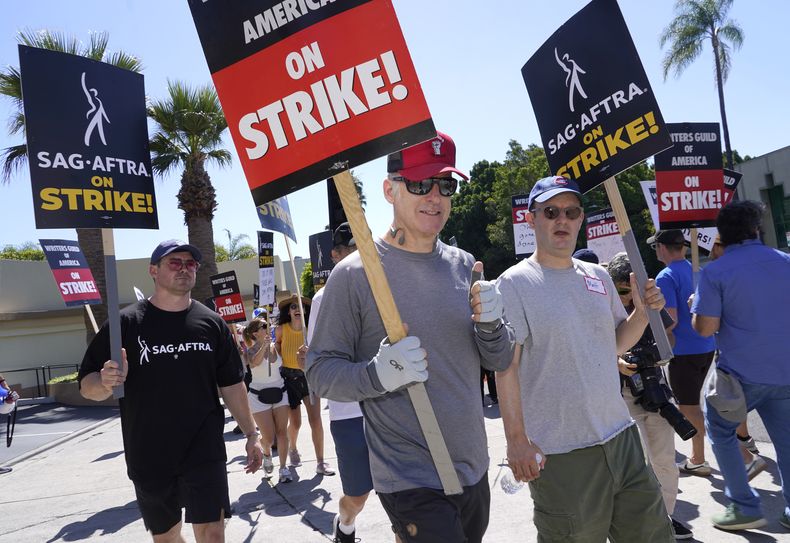 El actor Bob Odenkirk, centro, con un letrero durante una protesta fuera de los estudios Paramount el miércoles 19 de julio de 2023, en Los Angeles. (Foto AP/Chris Pizzello)