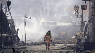 Un bombero camina entre los escombros y los restos de un incendio en un mercado, luego de un terremoto, en Wajima, en la prefectura de Ishikawa, Japón, el 2 de enero de 2024. (Kyodo News vía AP)