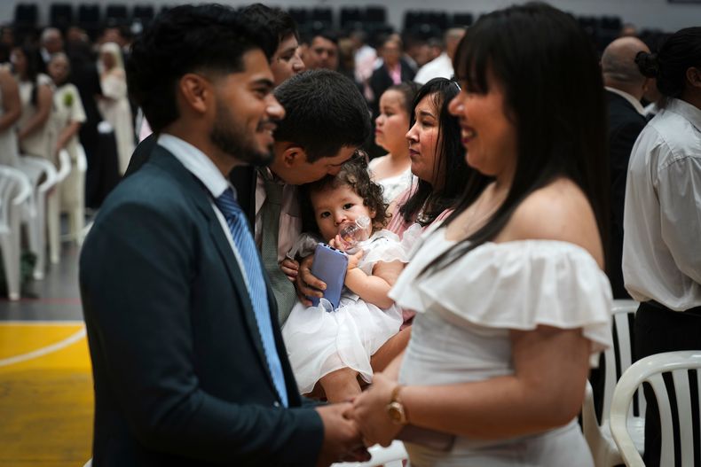 Parejas asisten a una ceremonia grupal organizada por el Registro Civil para formalizar legalmente su unión en Asunción, Paraguay, el sábado 4 de octubre de 2025. (Foto AP/Jorge Sáenz)