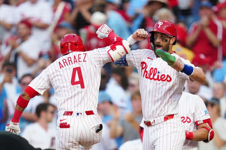 Luis Arráez (4), de los Filis de Filadelfia, celebra su cuadrangular de dos carreras con Bryce Harper luego de castigar al lanzador de los Marlins de Miami, Sandy Alcántara, durante la tercera entrada del juego de béisbol de Grandes Ligas, el miércoles 19 de agosto de 2026, en Filadelfia. (AP Foto/Derik Hamilton)
