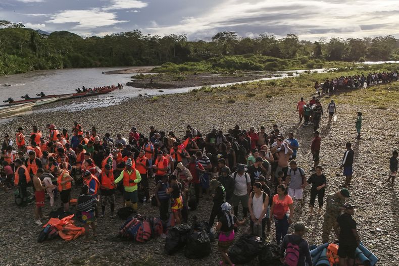 ARCHIVO - Migrantes se forman para abordar botes y poder continuar con su viaje hacia el norte para llegar a la frontera de Estados Unidos tras atravesar la región del Darién desde Colombia, en Bajo Chiquito, Panamá, el 9 de noviembre de 2024. (AP Foto/Matias Delacroix, Archivo)