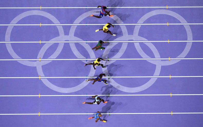 Noah Lyles (tercero desde abajo) corre rumbo a la victoria en la final de los 100 metros masculinos en los Juegos Olímpicos de París, el domingo 4 de agosto de 2024, en Saint-Denis, Francia. (AP Foto/David J. Phillip)