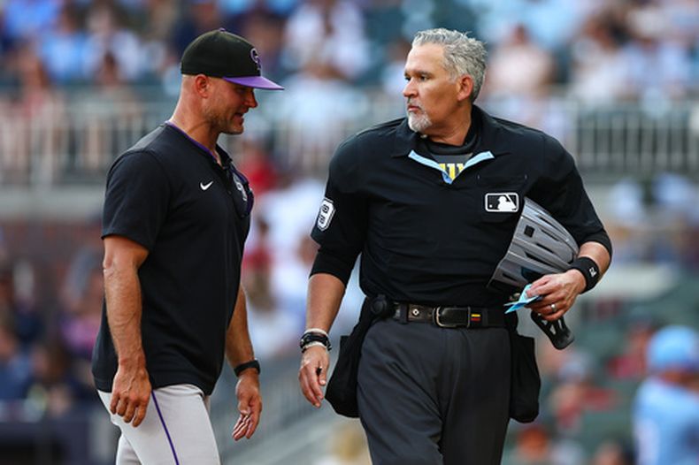 Warren Schaeffer, izquierda, mánager de los Rockies de Colorado, reacciona con el umpire principal Manny Gonzalez, derecha, quien tomó el lugar del lesionado Ron Kulpa en la séptima entrada del juego de béisbol de Grandes Ligas entre los Rockies de Colorado y los Bravos de Atlanta, el sábado 29 de agosto de 2026, en Atlanta. (AP Foto/Colin Hubbard)