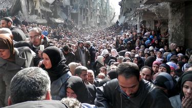 americateve | Esta foto tomada el 31 de enero de 2014 y proporcionada por la  Agencia de Naciones Unidas para los Refugiados Palestinos (UNRWA) se ven a habitantes de Yarmouk, una zona en Siria donde habitan palestinos, que acuden a recibir ayuda humanitaria. El confli