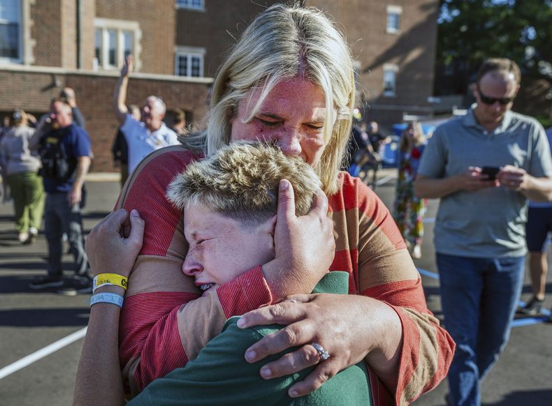 Una madre abraza a su hijo durante una situación de tirador activo en la iglesia de la Anunciación en Minneapolis, Minnesota, el miércoles 27 de agosto de 2025. (Richard Tsong-Taatarii/Star Tribune vía AP)