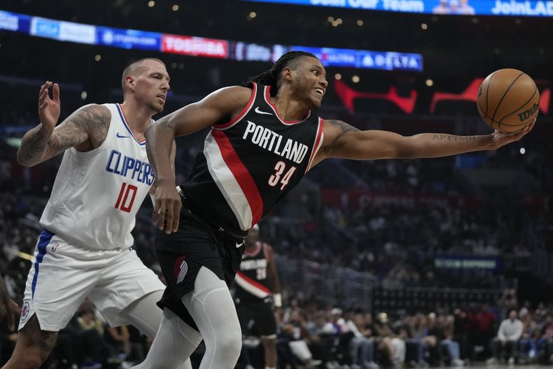 Jabari Walker (34), de los Trail Blazers de Portland, trata de capturar un rebote ante Daniel Theis, de los Clippers de Los Ángeles, durante la primera mitad del juego de la NBA que enfrentó a ambos equipos en Los Ángeles, el 11 de diciembre de 2023. (AP Foto/Ashley Landis)