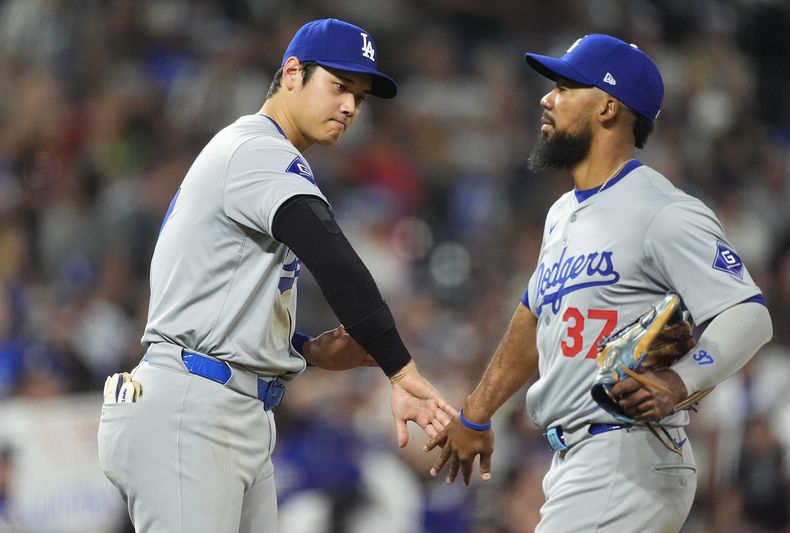 Shohei Ohtani (izquierda) de Los Ángeles Dodgers, felicita al jardinero izquierdo dominicano, Teoscar Hernández luego que los Dodgers vencieron a los Rockies de Colorado, el viernes 27 de septiembre de 2024, en Denver. (AP Foto/David Zalubowski)