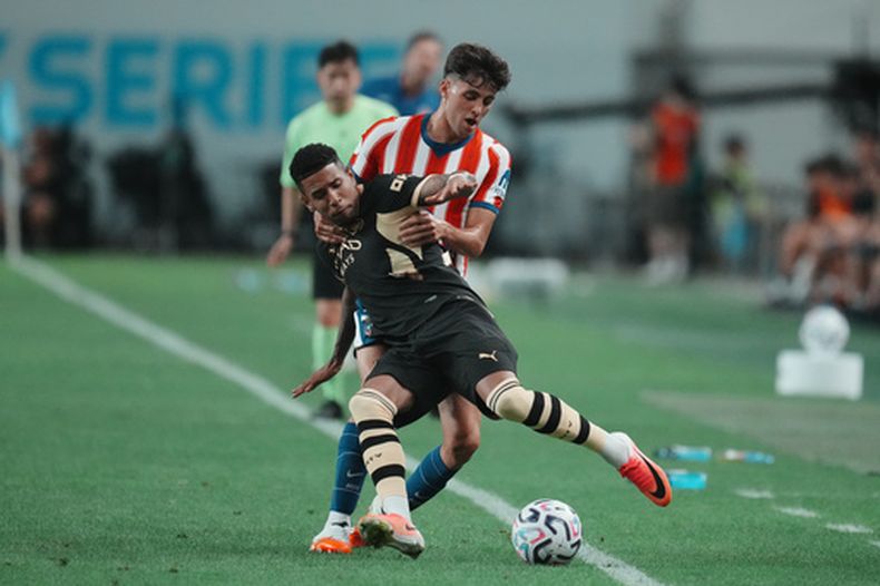 Dani Martínez (izquierda) del Atlético de Madrid pugna por el balón con Savinho del Manchester Cuty durante un amistoso de pretemporada, el domingo 9 de agosto de 2026, en Seúl. (AP Foto/Lee Jin-man)