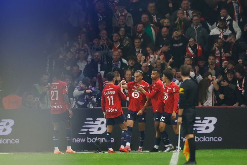 Ethan Mbappé, del Lille, centro, celebra con sus compañeros de equipo después de anotar el primer gol de su equipo durante el partido de fútbol de la Ligue 1 francesa entre el Lille y el Paris Saint-Germain en el Stade Pierre-Mauroy en Villeneuve-dAscq, cerca de Lille, Francia, el domingo 5 de octubre de 2025. (AP Photo/Jean-Francois Badias)