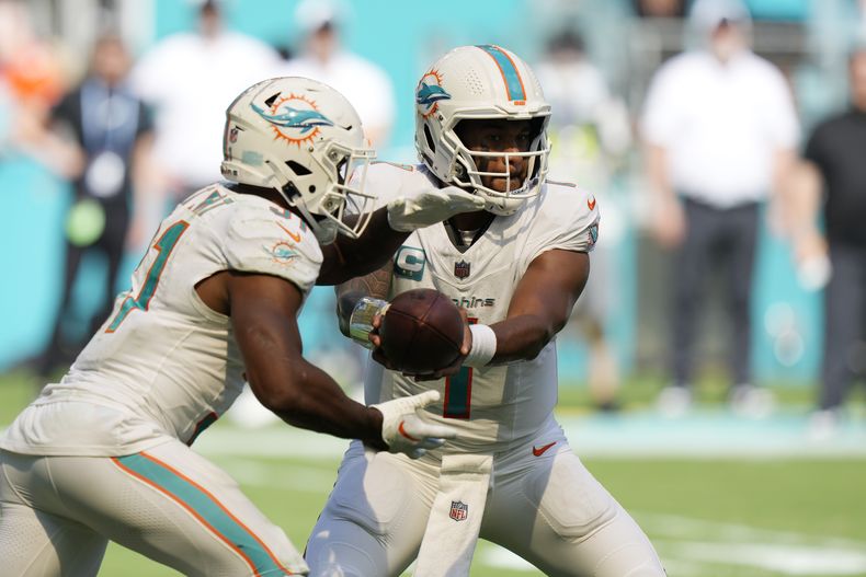 El quarterback de los Dolphins de Miami Tua Tagovailoa le entrega el balón al corredor Raheem Mostert durante el encuentro ante los Panthers de Carolina el domingo 15 de octubre del 2023. (AP Foto/Wilfredo Lee)
