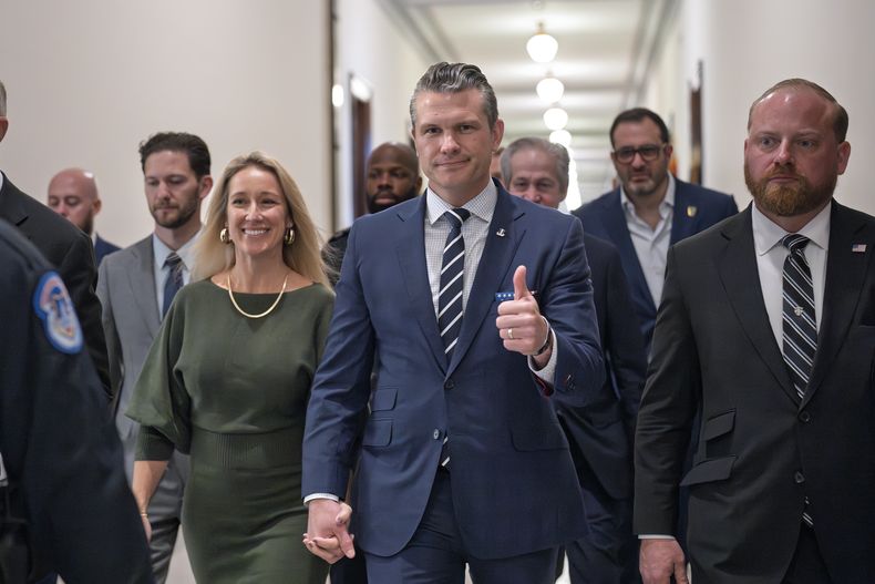Pete Hegseth, nominado por el presidente electo, Donald Trump, como secretario de Defensa, saluda mientras camina con su esposa, Jennifer Rauchet, izquierda, para reunirse con la senadora Joni Ernst, miembro de la Comisión de Servicios Armados del Senado, en el Capitolio, en Washington, el lunes 9 de diciembre de 2024. (AP Foto/J. Scott Applewhite)