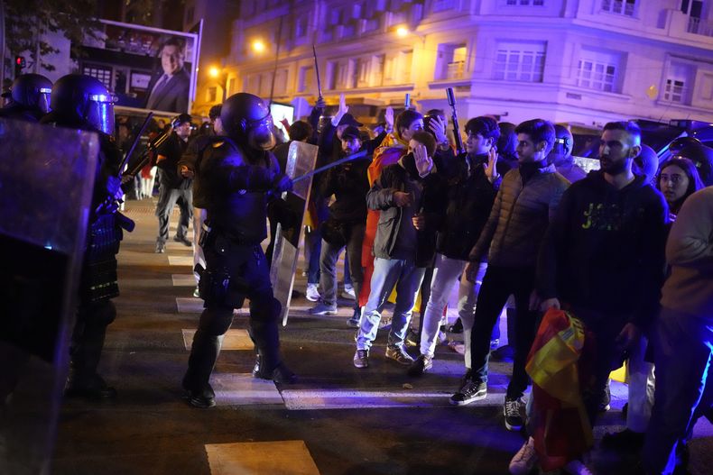 Policías antimotines dispersan una protesta contra la amnistía a separatistas catalanes frente a la sede del PSOE, el miércoles 15 de noviembre de 2023, en Madrid. (AP Foto/Manu Fernández)