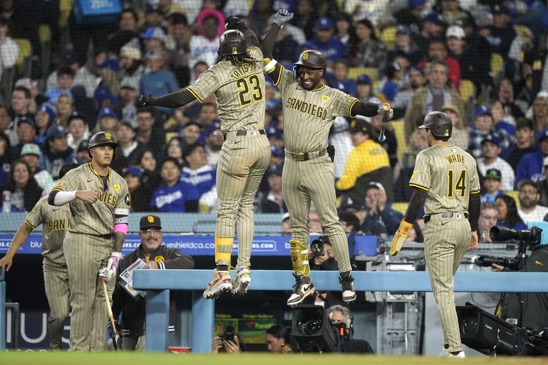 El dominicano Fernando Tatis (2do de izquierda a derecha) festeja tras batear un jonrón de dos carreras en el duelo ante los Dodgers de Los Ángeles, el viernes 12 de abril de 2024 (AP Foto/Mark J. Terrill)