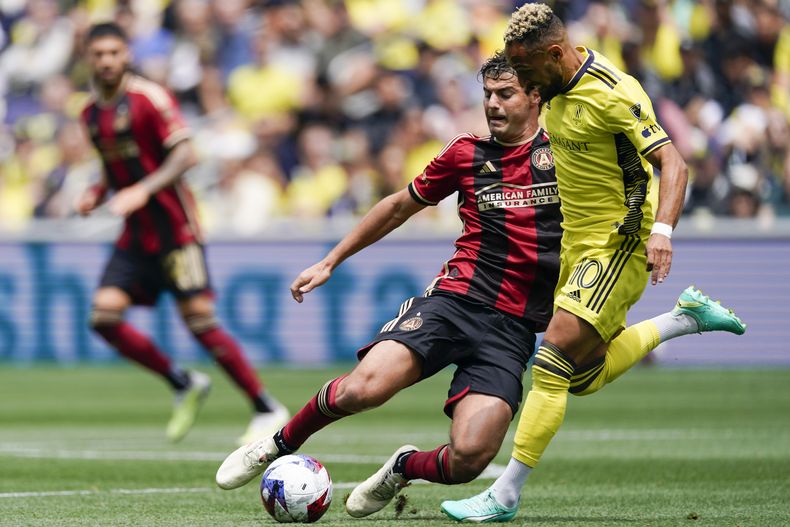 El mediocampista del Atlanta United Santiago Sosa patea el balón intentando superar al mediocampista de Nashville SC Hany Mukhtar en el encuentro de la MLS el sábado 29 de abril del 2023. (AP Foto/George Walker IV)