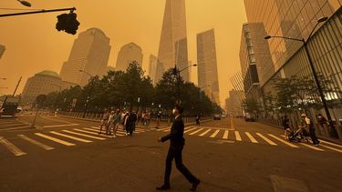 Peatones pasan junto al One World Trade Center (centro), en medio de la humareda causada por los incendios forestales en Canadá, el 7 de junio de 2023, en la Ciudad de Nueva York. (AP Foto/Julie Jacobson)