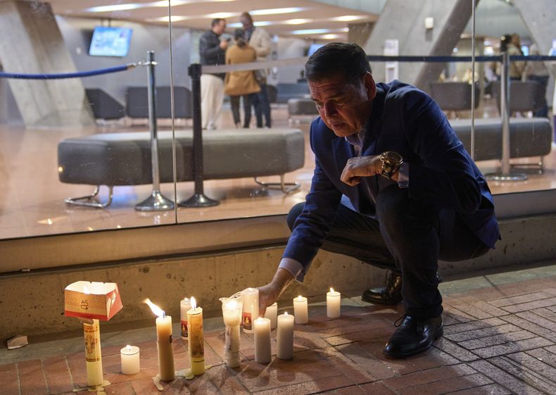 Un hombre enciende velas afuera de la clínica donde el senador colombiano Miguel Uribe Turbay recibe atención médica tras recibir disparos en un mitin político en Bogotá, Colombia, el domingo 8 de junio de 2025. (AP Foto/Ramón Espinosa)