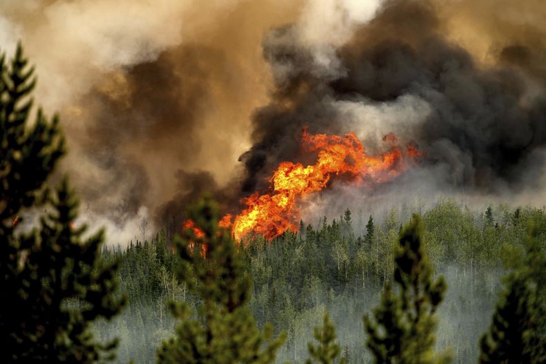 Llamas del incendio forestal Donnie Creek arden a lo largo de una cresta al norte de Fort St. John, Columbia Británica, Canadá, el domingo 2 de julio de 2023. (AP Foto/Noah Berger)