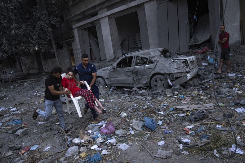 Palestinos caminan entre escombros luego de ataques israelíes contra una extensa zona de un vecindario en la Ciudad de Gaza, el martes 10 de octubre de 2023. Hamas, el grupo islamista que gobierna la Franja de Gaza, llevó a cabo un ataque sin precedentes el sábado contra Israel, en donde mató a más de 1.000 personas y secuestró a varias más. Israel respondió con intensos ataques aéreos contra el territorio que dejaron a cientos de palestinos muertos. (AP Foto/Fatima Shbair)