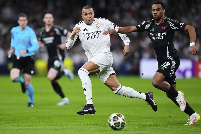 ARCHIVO - Kylian Mbappé del Real Madrid pugna por el balón contra Jurrien Timber (derecha) de Arsenal en la vuelta de los cuartos de final de la Liga de Campeones, el 16 de abril de 2025. (AP Foto/Manu Fernández)