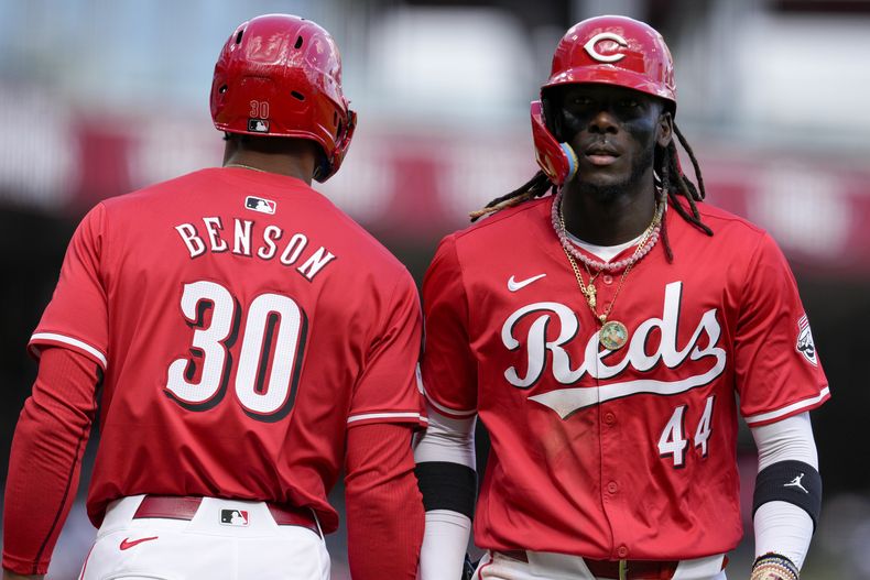 El dominicano Elly de la Cruz festeja con Will Benson, su compañero en los Rojos de Cincinnati, tras anotar en el juego ante los Mets de Nueva York, el sábado 6 de abril de 2024 (AP Foto/Jeff Dean)