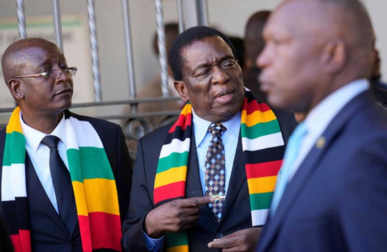 El presidente de Zimbabue Emmerson Mnangagwa (cent) con su ministro de Justicia Ziyambi Ziyambi (izq) afuera del tribunal de nominaciones en Harare, Zimbabue, el 21 de junio del 2023. (AP foto/Tsvangirayi Mukwazhi)