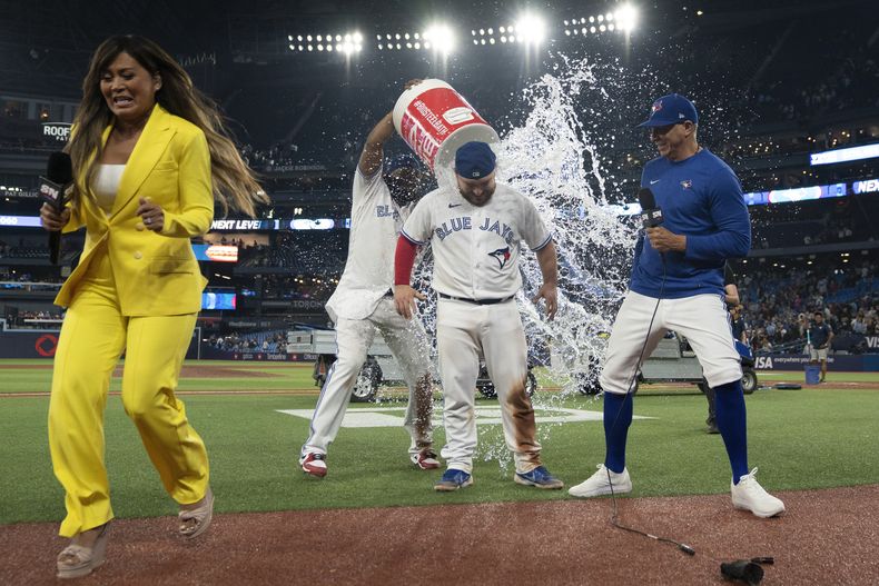 El dominicano Vladimir Guerrero Jr. vacía la hielera encima del mexicano Alejandro Kirk, para festejar la victoria de los Azulejos de Toronto sobre los Astros de Houston, el jueves 8 de junio de 2023 (Chris Young/The Canadian Press via AP)