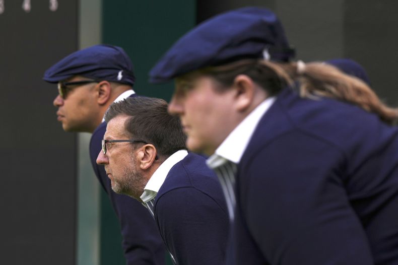 ARCHIVO - Los jueces de línea se concentran mientras el ruso Daniil Medvedev juega contra el británico Arthur Fery en un partido de primera ronda de individuales masculinos en el tercer día del campeonato de tenis de Wimbledon en Londres, el miércoles 5 de julio de 2023. Esa larga tradición de Wimbledon de jueces de línea vestidos con elegantes uniformes dejará de existir. El All England Club ha anunciado que se utilizará la inteligencia artificial para hacer las llamadas de out y fault en los campeonatos a partir de 2025. (AP Foto/Alberto Pezzali, Archivo)
