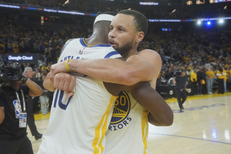 Jimmy Butler III abraza a Stephen Curry, su compañero de los Warriors de Golden State, tras doblegar a los Grizzlies de Memphis en el play-in, el martes 15 de abril de 2025 (AP Foto/Jeff Chiu)