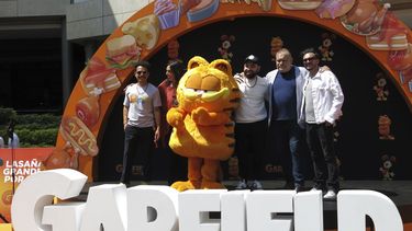 Un artista disfrazado como el personaje Garfield, centro, con los actores de doblaje Guillermo Memo Villegas, de izquierda a derecha, Regina Orozco, Jose Luis Slobotzky, Joaquín Cosio y Ricardo Pérez, posan en la alfombra naranja de la versión en español para Latinoamérica de The Garfield Movie en la Ciudad de México el domingo 28 de abril de 2024. (Foto AP/Berenice Bautista)