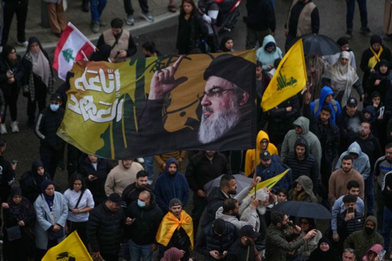 Un partidario de Hezbollah ondea una bandera con el retrato del difunto líder del grupo, Sayyed Hassan Nasrallah, durante una protesta contra el primer ministro libanés Nawaf Salam, frente al palacio de gobierno en Beirut, Líbano, el viernes 10 de abril de 2026. (AP Foto/Hussein Malla)