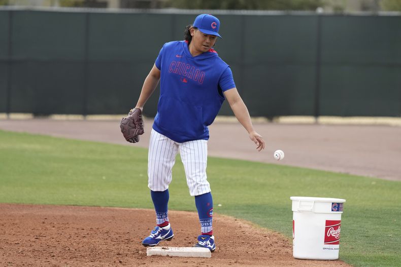 El lanzador japonés de los Cachorros de Chicago, Shota Imanaga, lanza una pelota de béisbol en un balde durante los ejercicios de fildeo en las instalaciones de entrenamiento de primavera de béisbol de los Cachorros, el lunes 17 de febrero de 2025, en Mesa, Arizona (AP Foto/Ross D. Franklin)