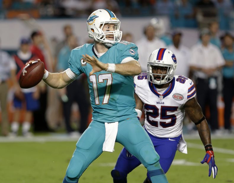 Ryan Tannehill, de los Dolphins de Miami, se prepara para lanzar un pase, mientras se acerca a &eacute;l DaNorris Searcy, de los Bills de B&uacute;falo, en el encuentro del jueves 13 de noviembre de 2014 (AP Foto/Alan D&iacute;az)