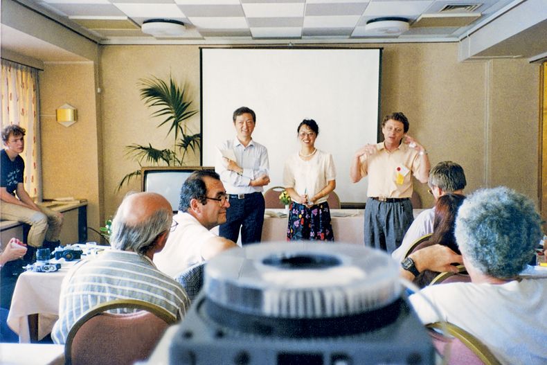 En esta fotografía de agosto de 1990 proporcionada por Eight Light Minutes Culture, la editora de Science Fiction World Yang Xiao, centro, junto al burócrata de la provincia de Sichuan Shen Zaiwang, izquierda, y el autor estadounidense de ciencia ficción Norman Spinrad, derecha, durante la Convención Mundial de Ciencia Ficción realizada en La Haya, Paises Bajos. El viaje de Yang y Shen a La Haya ayudó a convencer a autores internacionales de que podían viajar de forma segura a la primera convención internacional de ciencia ficción en China. (Foto AP/Eight Light Minutes Culture)
