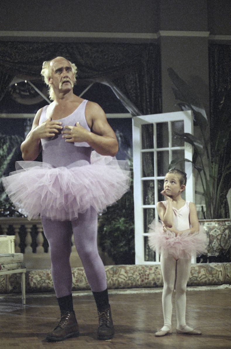 ARCHIVO - El luchador profesional Terry Bollea, mejor conocido como Hulk Hogan, y la actriz de 6 años Madeline Zima esperan la señal del director durante el rodaje de la comedia Mr. Nanny, el 11 de junio de 1992 en Miami, Florida. Hogan interpreta a Sean Armstrong, un exluchador contratado para proteger a dos niños adinerados. (Foto AP/Kathy Willens, archivo)